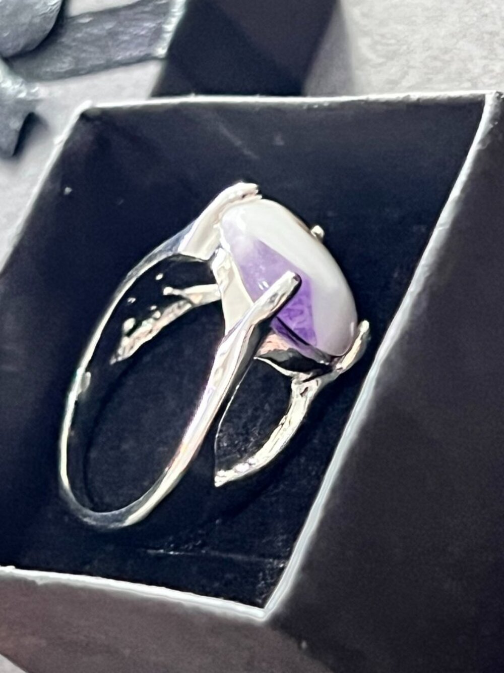 Elegant silver-tone statement ring featuring oval white stone with beautiful pur